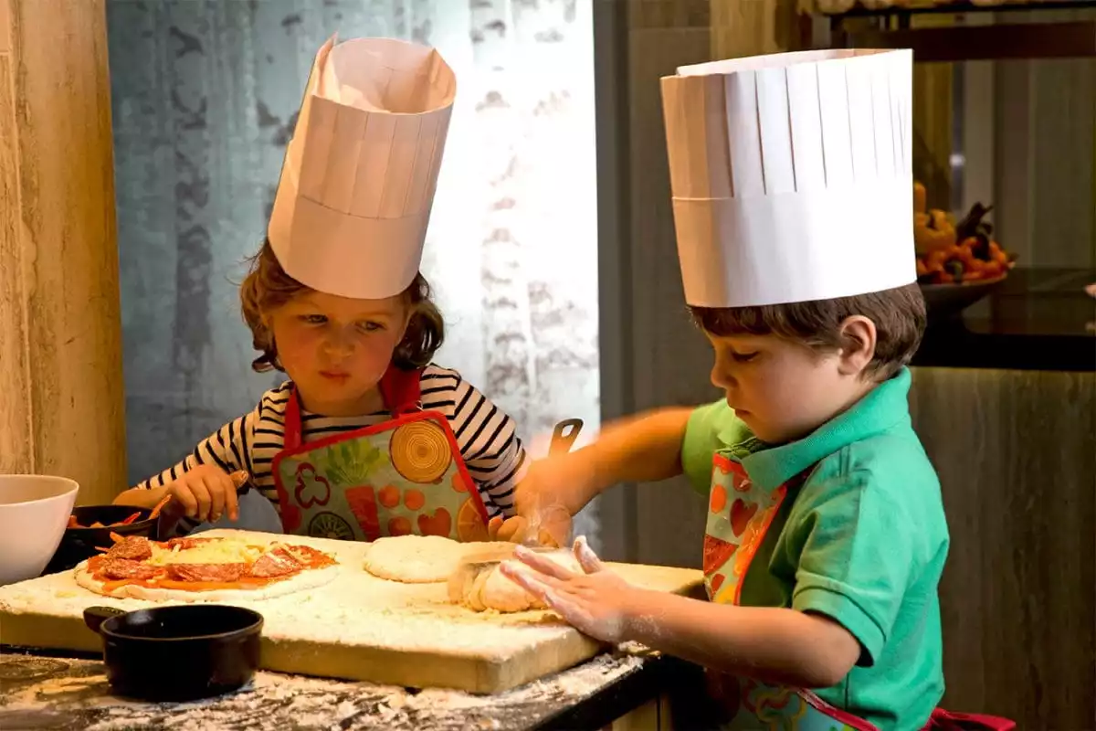 Children in chefs hats eating
